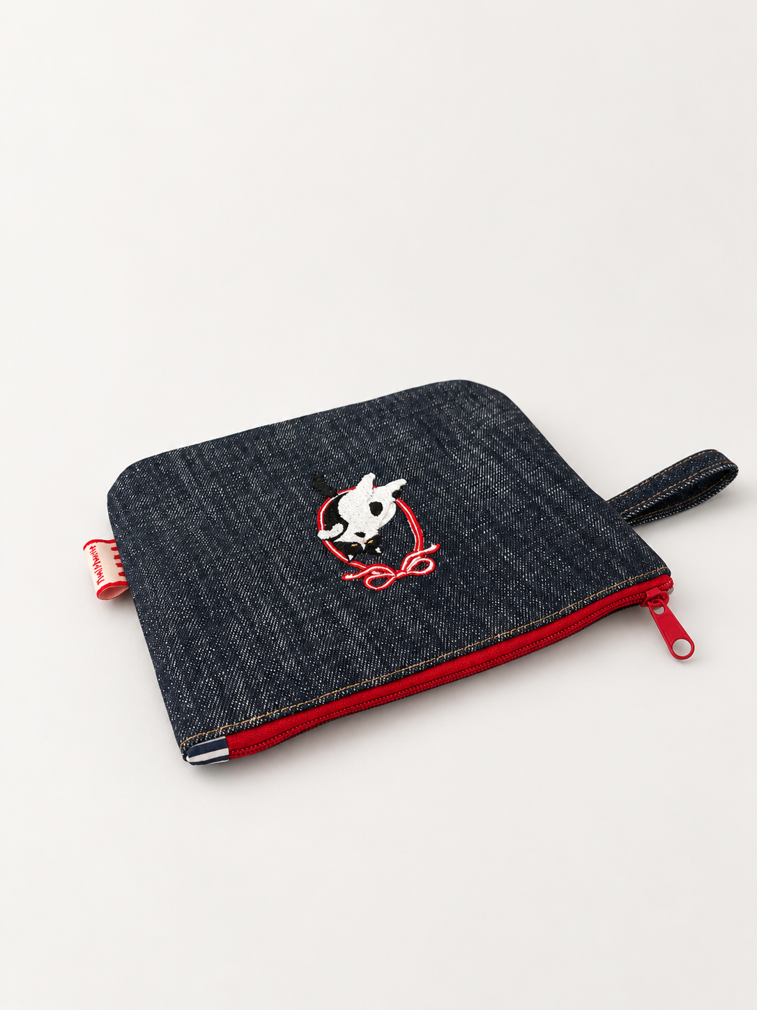 Angled view of Cat Style 1 large denim pouch with red zip and carrying loop