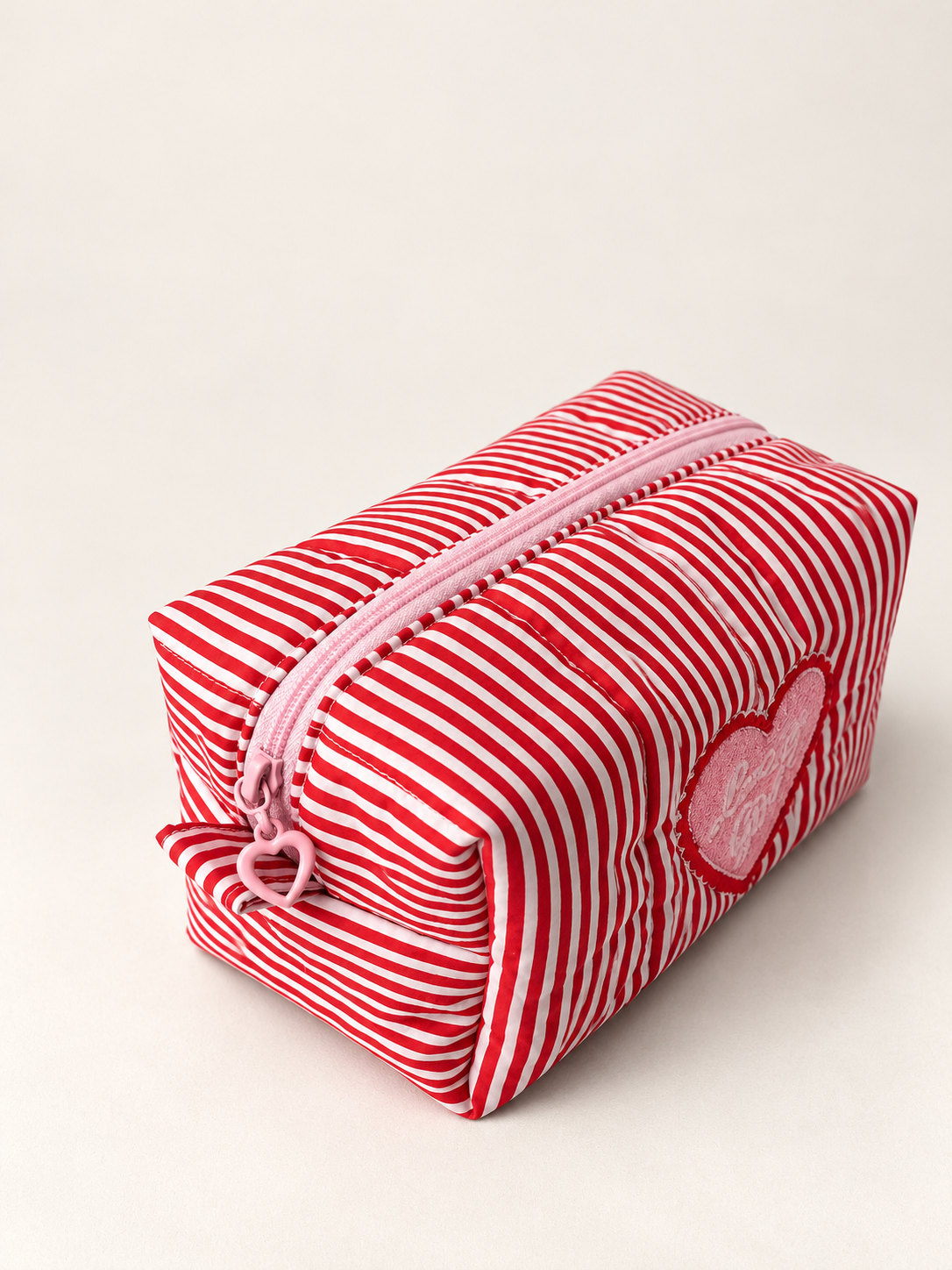 Top detail of Lucky Girl makeup bag showing the pink heart-shaped zipper pull